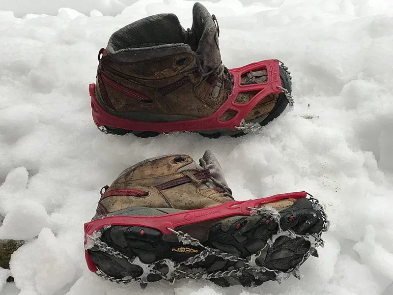 Microspikes fitted to hiking boots on snow, illustrating microspike rental in El Chaltén